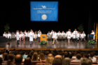 An incoming medical student walks across the stage after being coated.